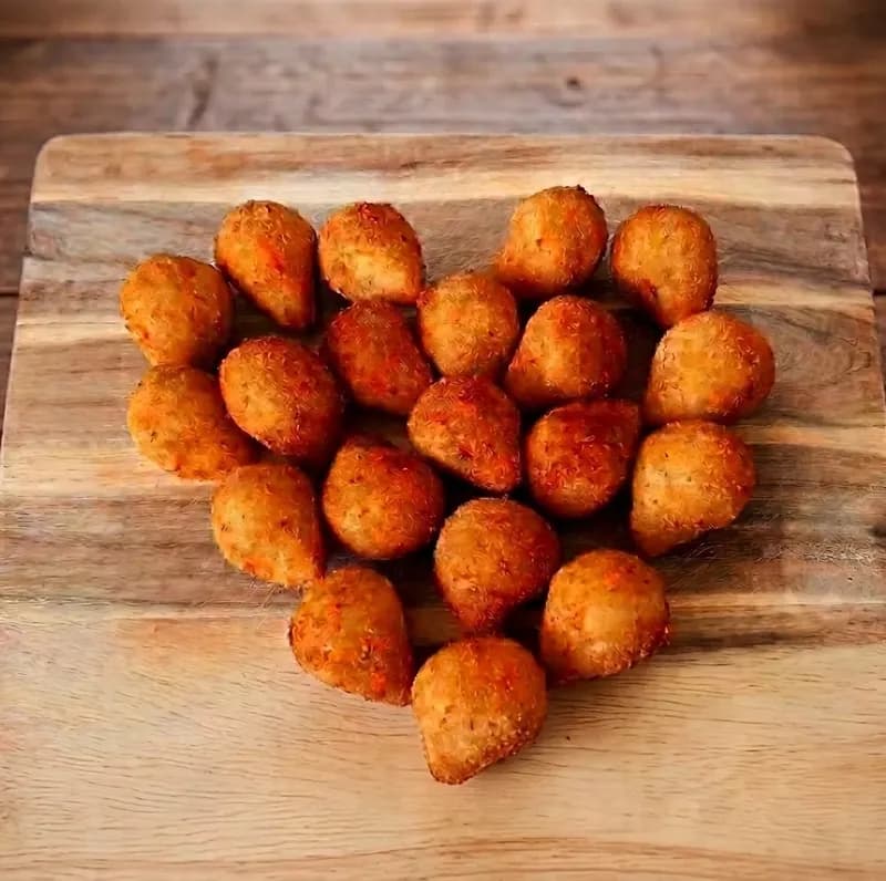 Coxinhas arranged in a heart on a wooden board